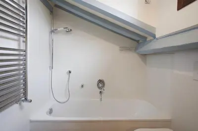 a bathroom with a bath tub with a shower at Laurina F1 Studio with Panoramic Terrace - LOCAPPART in Rome