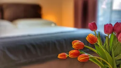 a bunch of flowers in a vase next to a bed at RELAX Palace in Rome