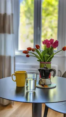 a table with two cups and a vase with flowers at RELAX Palace in Rome