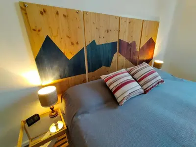 a bedroom with a large bed with a wooden headboard at Attico Luminoso Bed in Bormida in Rome