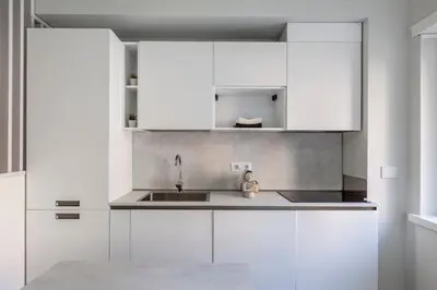 a kitchen with white cabinets and a sink at Vatican Suites in Rome