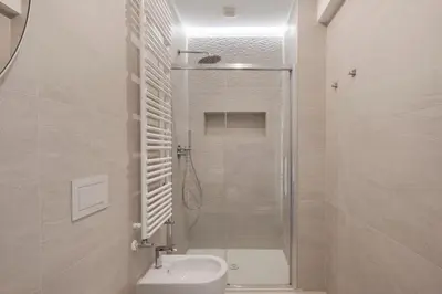 a white bathroom with a shower and a toilet at Vatican Suites in Rome