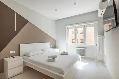 a white bedroom with a white bed and a staircase at Vatican Suites in Rome