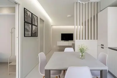 a dining room with a table and white chairs at Vatican Suites in Rome
