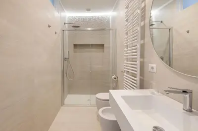 a bathroom with a shower and a toilet and a sink at Vatican Suites in Rome
