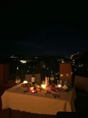 a table with candles and plates of food and wine glasses at Vatican Rooftop Studio - NEW OPENING in Rome