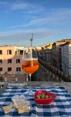 a glass of wine and a bowl of food on a table at Vatican Rooftop Studio - NEW OPENING in Rome