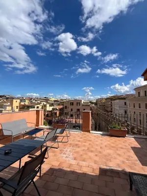 a patio with tables and chairs on a roof at Vatican Rooftop Studio - NEW OPENING in Rome