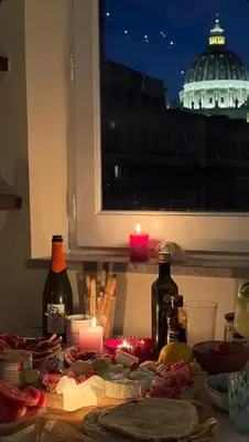 a table with a candle and some food and bottles at Vatican Rooftop Studio - NEW OPENING in Rome