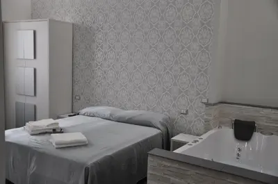 a bedroom with a bed and a tub and a sink at Imperial Relais in Rome
