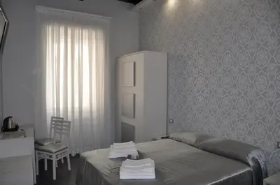a bedroom with a bed and a desk and a chair at Imperial Relais in Rome