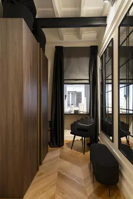 a living room with a black chair and a window at Acque Romane Maison Trevi Crociferi in Rome