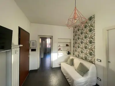 a living room with a white couch and a wall at Appartamento Boho a San Lorenzo ,quartiere della street art in Rome