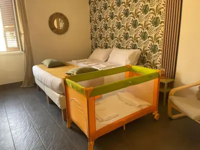a small bedroom with a bed and a crib at Appartamento Boho a San Lorenzo ,quartiere della street art in Rome