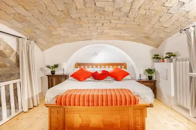 a bedroom with a large bed with orange pillows at La Casetta Aureliana in the center of the capital in Rome