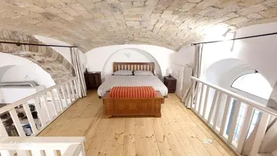 a bedroom with a bed in a room with stairs at La Casetta Aureliana in the center of the capital in Rome