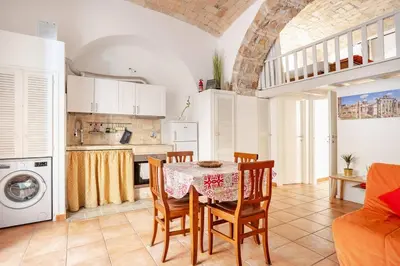 a kitchen and dining room with a table and chairs at La Casetta Aureliana in the center of the capital in Rome