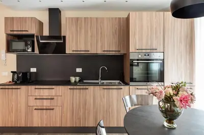 a kitchen with wooden cabinets and a table with a vase of flowers at ROMAN DREAM lV in Rome