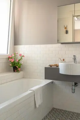 a white bathroom with a tub and a sink at Trastevere Station Apartment View in Rome