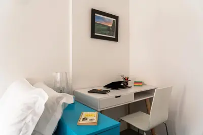 a bedroom with a bed and a desk with a chair at Trastevere Station Apartment View in Rome