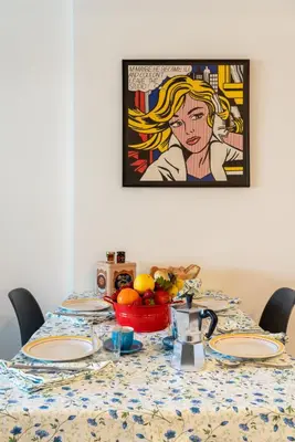 a table with plates and a bowl of fruit on it at Trastevere Station Apartment View in Rome