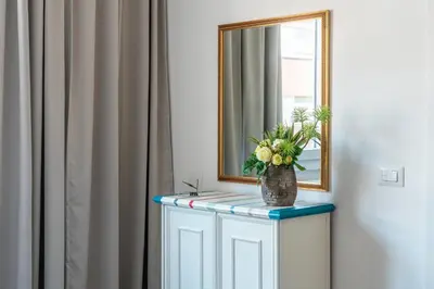 a bathroom with a mirror and a vase of flowers at Trastevere Station Apartment View in Rome