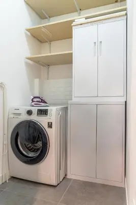 a washer and dryer in a white laundry room at Trastevere Station Apartment View in Rome