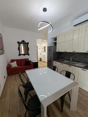 a kitchen and living room with a white table and chairs at Maison Simone Marconi in Rome