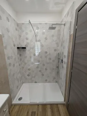 a bathroom with a shower with a glass door at Maison Simone Marconi in Rome