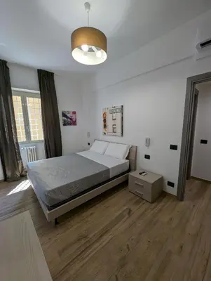 a large bedroom with a bed and a lamp at Maison Simone Marconi in Rome