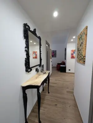a mirror on a wall with a wooden table at Maison Simone Marconi in Rome