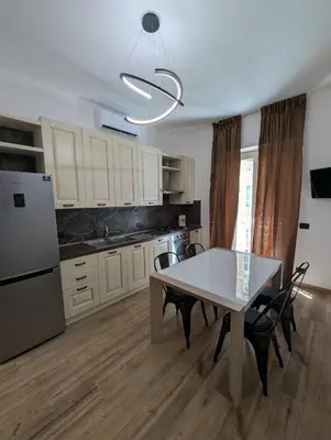 a kitchen with a table and chairs and a refrigerator at Maison Simone Marconi in Rome