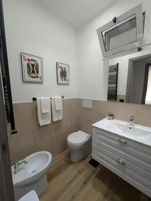 a bathroom with a sink and a toilet and a mirror at Maison Maurizio Marconi in Rome