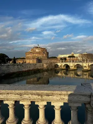 a bridge over a river in front of a building at Le Case di Emma in Rome