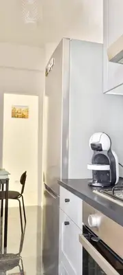 a kitchen with a refrigerator and a table and a chair at Appartamento Roma San Giovanni in Rome
