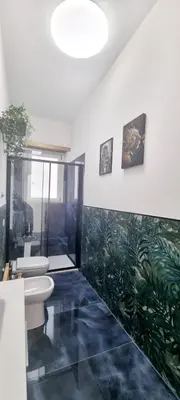 a bathroom with two toilets and a green mural on the wall at Appartamento Roma San Giovanni in Rome