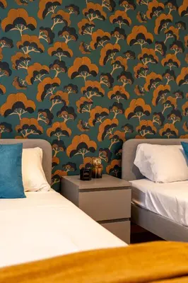 a bedroom with two beds and a blue and orange wallpaper at Maia - Luxury Apartment in Monteverde in Rome