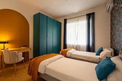 a hotel room with two beds and a desk at Maia - Luxury Apartment in Monteverde in Rome