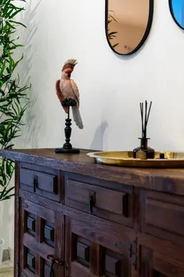 a bird sitting on top of a wooden dresser at Maia - Luxury Apartment in Monteverde in Rome