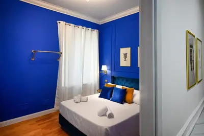 a blue bedroom with a bed with blue walls at Royal Blue - Holiday Apartment in Rome