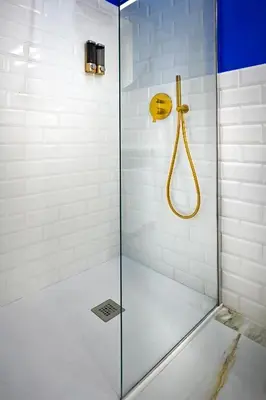 a shower with a yellow shower head and a glass door at Royal Blue - Holiday Apartment in Rome