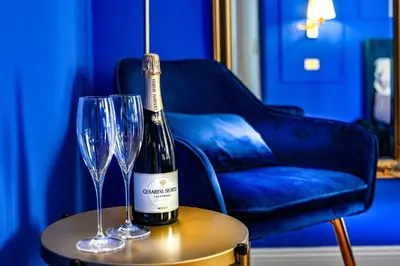 a bottle of wine and two glasses on a table at Royal Blue - Holiday Apartment in Rome
