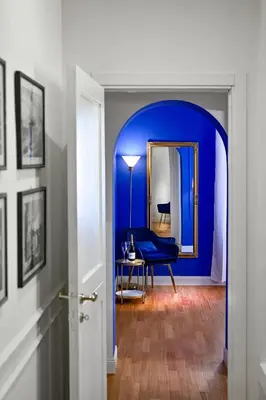 a blue room with a blue chair and a mirror at Royal Blue - Holiday Apartment in Rome