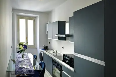 a kitchen with a table with a vase of flowers on it at Royal Blue - Holiday Apartment in Rome