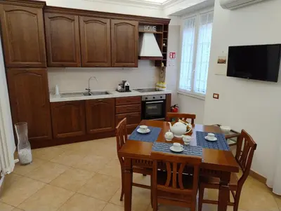 a kitchen with a wooden table and chairs and a kitchen with a sink at Alcinque - Casa vacanze in Rome