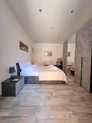 a bedroom with a large bed and a desk at San Lorenzo Garden Suites in Rome