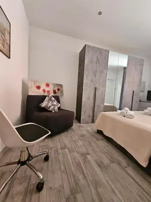 a bedroom with a bed and a chair and a desk at San Lorenzo Garden Suites in Rome