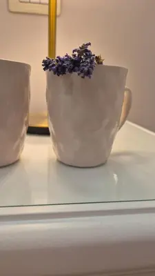 a white vase with a plant in it on a table at Sweet Saint Paul in Rome