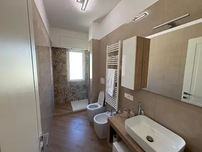 a bathroom with a toilet and a sink and a mirror at Saint Peter's Sunset View Luxury Apartment in Rome