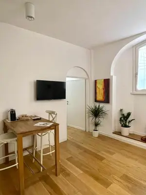 a living room with a table and a tv on the wall at Domus 31 - Colosseum in Rome